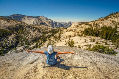 Full length of man standing on rock against sky