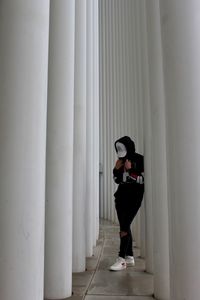 Full length of young woman standing in corridor