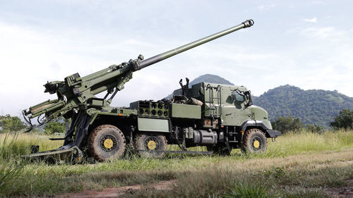 Armored tank on field against sky