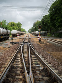 People on railroad tracks against sky