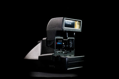 Close-up of camera on table against black background