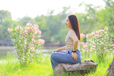 Side view of woman sitting on grass