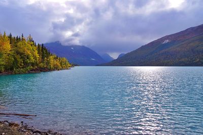 Scenic view of lake by mountains against sky