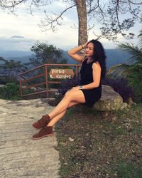 Portrait of smiling young woman sitting outdoors