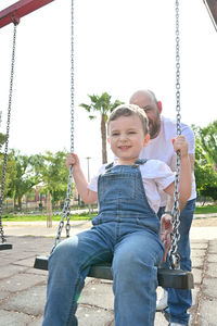 Portrait of boy swinging in playground