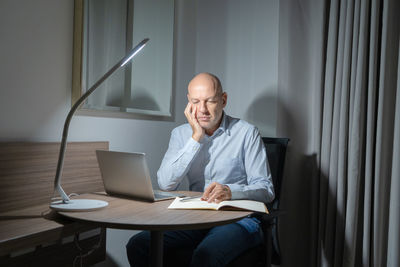 Man using mobile phone while sitting on table