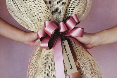 Cropped hands of people holding tied gift