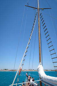 Sailboat sailing in sea against clear blue sky