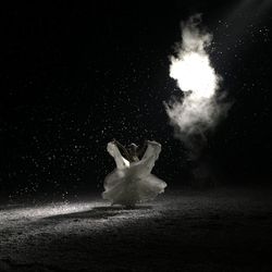 Woman dancing outdoors at night