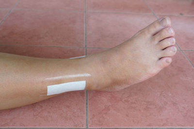 Low section of person with bandage on floor