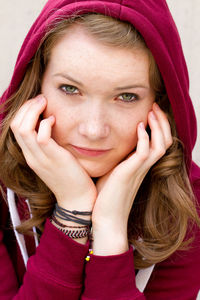 Close-up portrait of young woman in hood - clothing