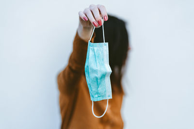 Midsection of woman holding umbrella against white background