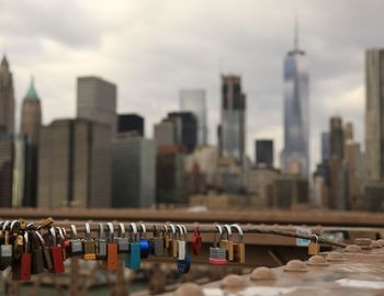 Close-up of padlocks against cityscape