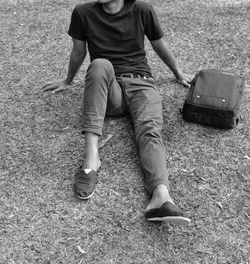 Low section of man sitting on grassy field