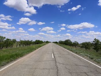 Road amidst trees against sky