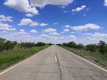 Road amidst trees against sky