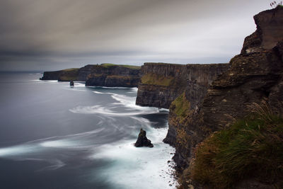 Rock formations by sea against sky