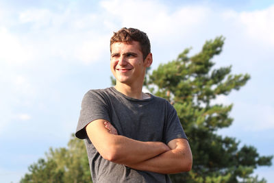 Low angle view of young man standing against sky