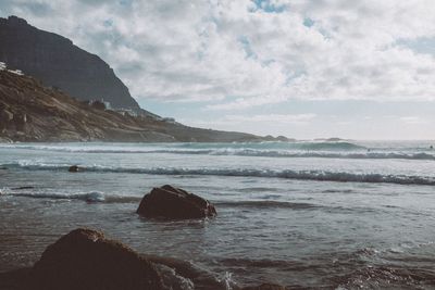 Scenic view of sea and mountains against sky