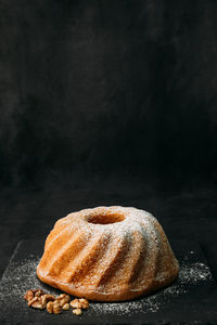 Close-up of bread on stack against black background