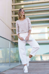 Portrait of young woman standing in city