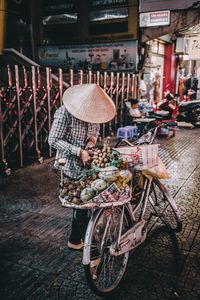 Low section of vendor standing by bicycle with food on footpath