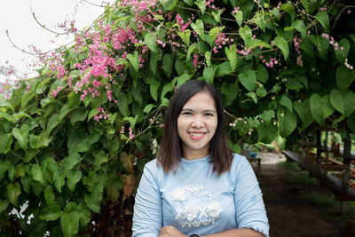 Portrait of smiling woman by plants 