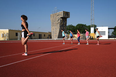 Group of people running against clear sky