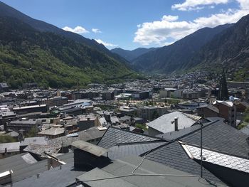 Aerial view of townscape and mountains against sky