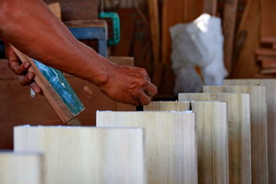 Cropped hands of man working on wood in workshop