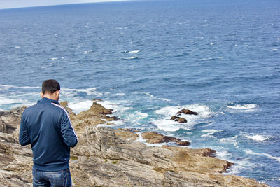 Rear view of man standing on beach