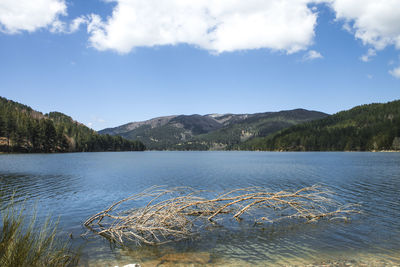 Scenic view of lake by mountains against sky