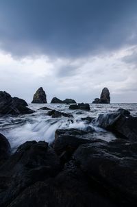 Rocks on beach against sky