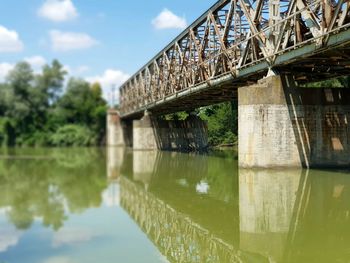 Arch bridge over river against sky