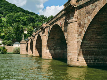 Arch bridge over river against sky