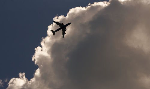 Low angle view of silhouette airplane flying in sky