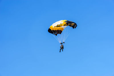 Low angle view of kite flying against clear blue sky