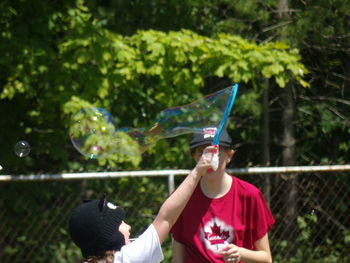 Rear view of man and woman holding bubbles