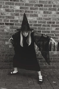 Rear view of woman standing on brick wall