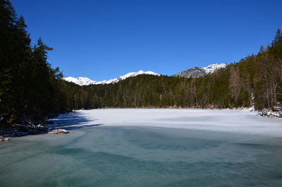 Scenic view of snowcapped mountains against clear blue sky