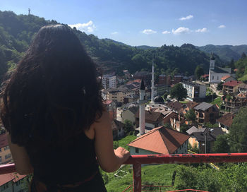 Rear view of woman looking at buildings against sky