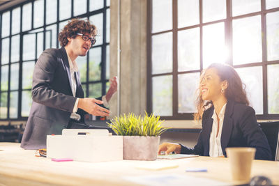 Colleagues in a boardroom discussion, seated at a table together,