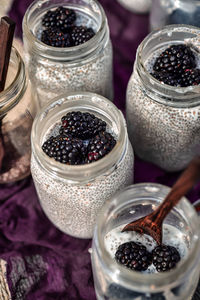 Chia seed and almond. milk pudding topped with blackberries all in glass jars