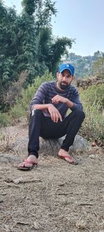 Portrait of young man sitting on land
