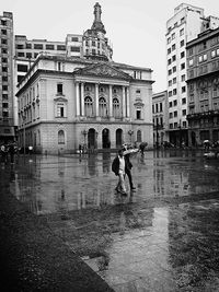 Woman standing by building in city