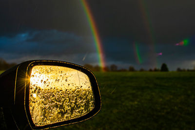 Reflection of rainbow on side-view mirror