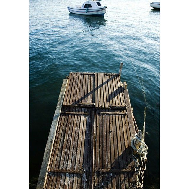 water, nautical vessel, transportation, mode of transport, boat, sea, moored, railing, pier, transfer print, rippled, day, wood - material, auto post production filter, no people, metal, high angle view, outdoors, travel, river