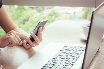 Businesswoman using technologies at table in cafe