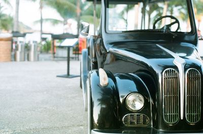 Close-up of old car on street in city