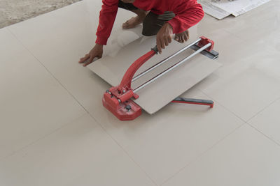Low section of worker installing tile